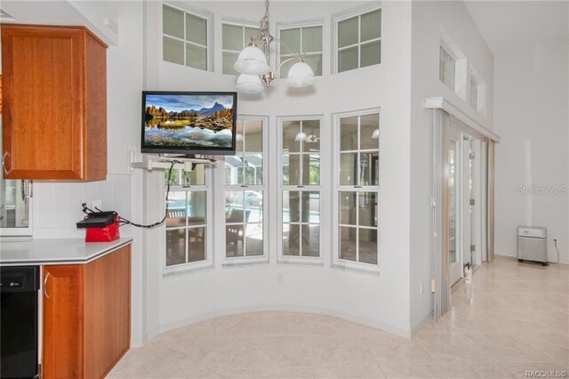 tiled dining room featuring a high ceiling and an inviting chandelier