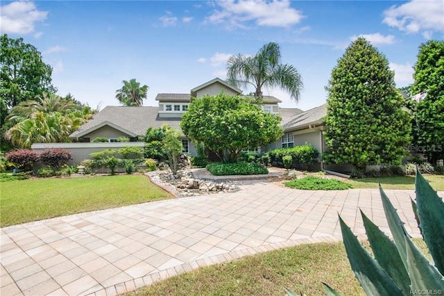 view of property hidden behind natural elements with a front lawn