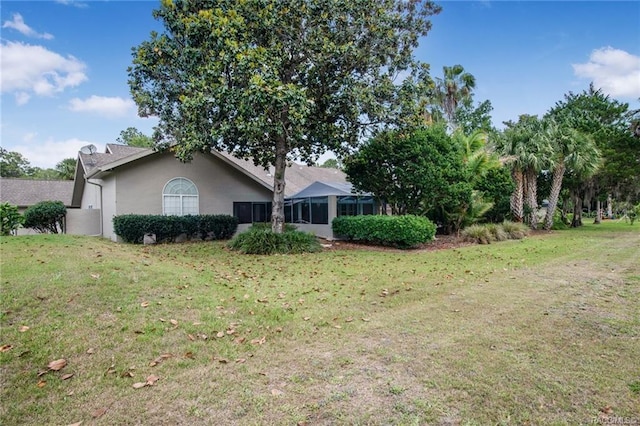 view of front of property with a sunroom and a front lawn