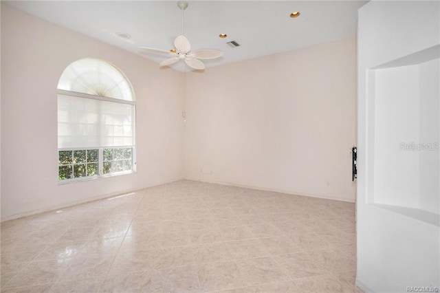 spare room with ceiling fan and light tile patterned floors