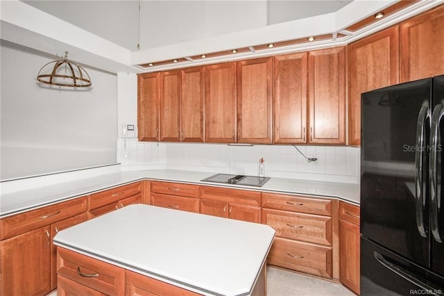 kitchen with decorative backsplash, a kitchen island, black appliances, and light tile patterned floors