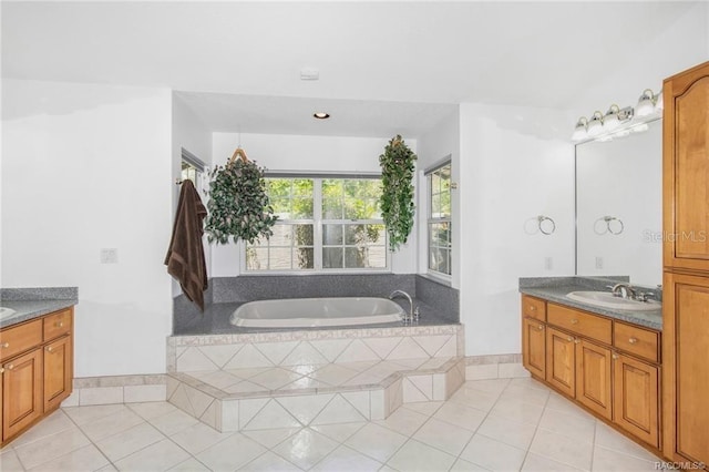 bathroom with tile patterned floors, tiled tub, and vanity