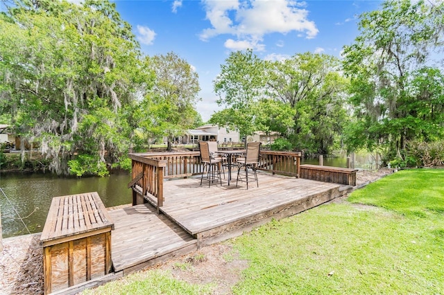 wooden terrace featuring a water view and a lawn