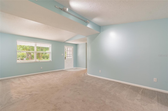 empty room with carpet and a textured ceiling