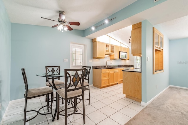 kitchen featuring light carpet, light brown cabinetry, a textured ceiling, ceiling fan, and sink