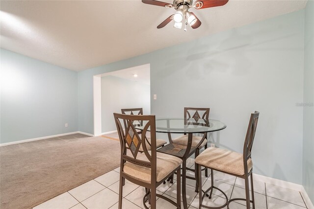 carpeted dining room with ceiling fan