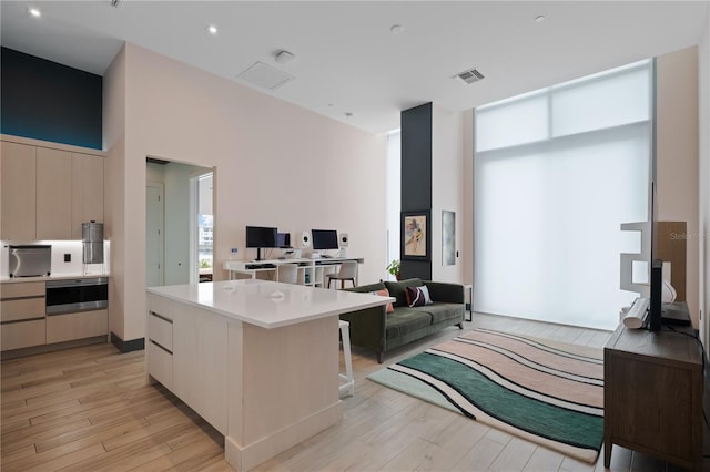 kitchen with white cabinets, light hardwood / wood-style flooring, and a kitchen island