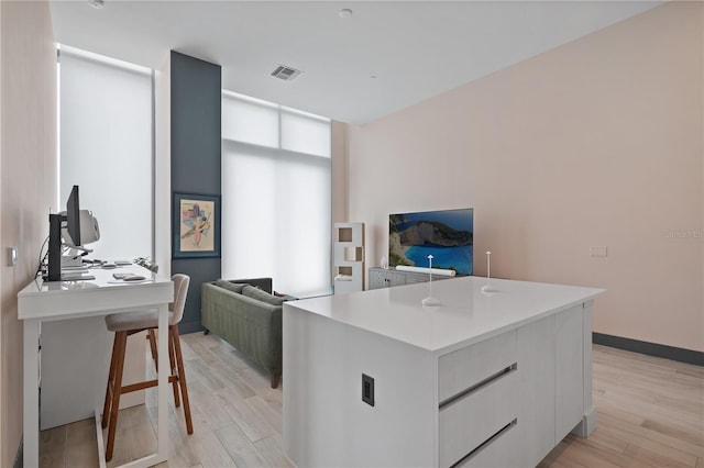 kitchen featuring white cabinetry, a kitchen island, and light hardwood / wood-style flooring