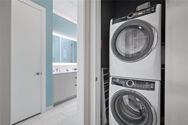 clothes washing area featuring stacked washer / dryer