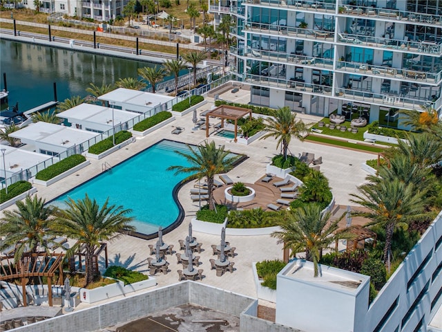 view of swimming pool featuring a water view and a patio area