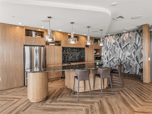 bar featuring dark stone countertops, parquet floors, hanging light fixtures, and wooden walls