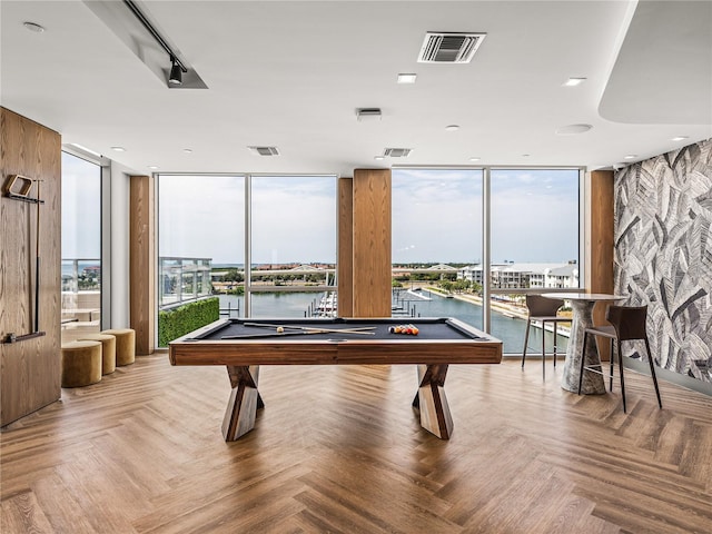 rec room featuring a water view, pool table, parquet floors, and a wall of windows