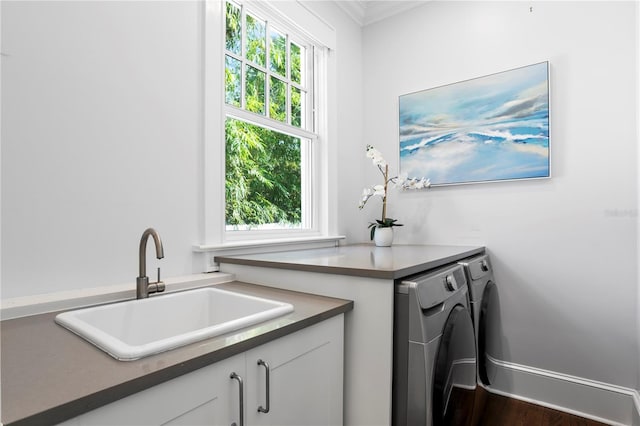 washroom with washer and dryer, dark wood-type flooring, a healthy amount of sunlight, and sink