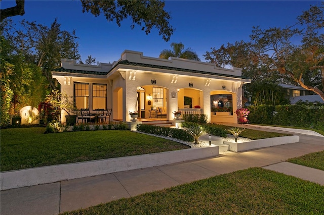 view of front of property featuring covered porch and a front yard