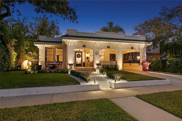 view of front of home featuring covered porch and a front lawn