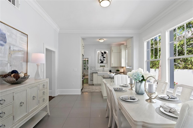 dining room with crown molding and dark tile patterned floors