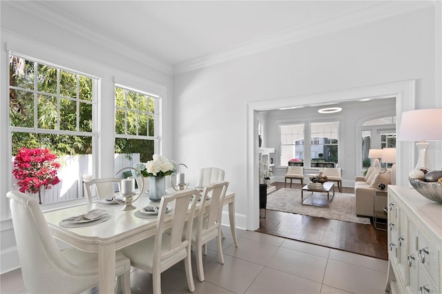 dining area with ornamental molding, light hardwood / wood-style floors, and a healthy amount of sunlight