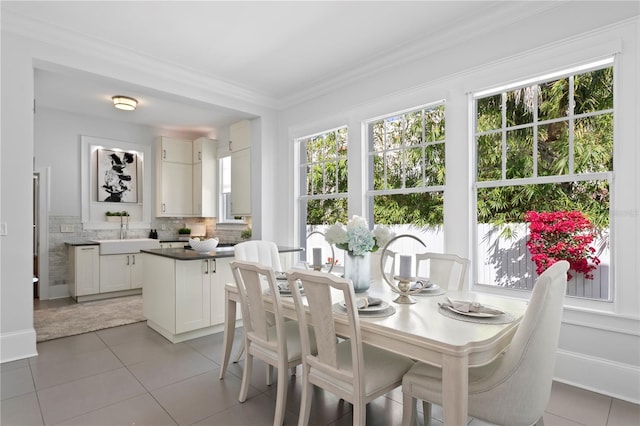 tiled dining space with crown molding and sink