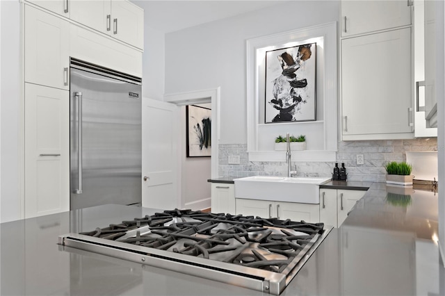 kitchen featuring white cabinets, decorative backsplash, sink, and stainless steel appliances