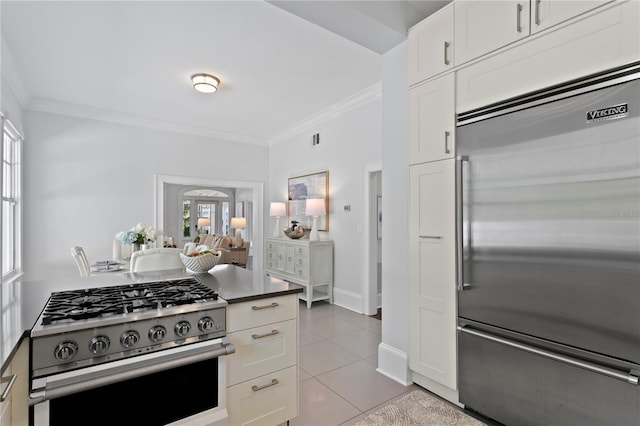 kitchen featuring white cabinetry, crown molding, light tile patterned floors, and stainless steel appliances