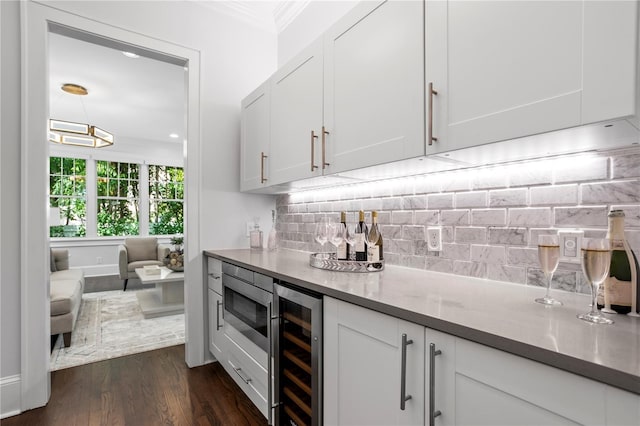 bar with decorative backsplash, dark hardwood / wood-style flooring, crown molding, white cabinets, and wine cooler