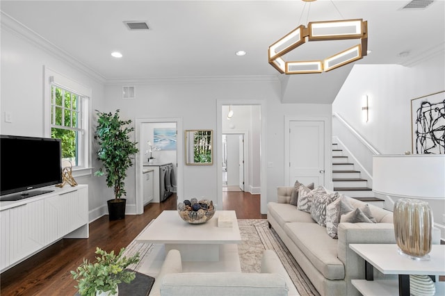 living room with dark hardwood / wood-style flooring, separate washer and dryer, crown molding, and an inviting chandelier