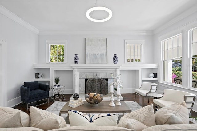 living room featuring a tiled fireplace, built in shelves, dark hardwood / wood-style floors, and ornamental molding