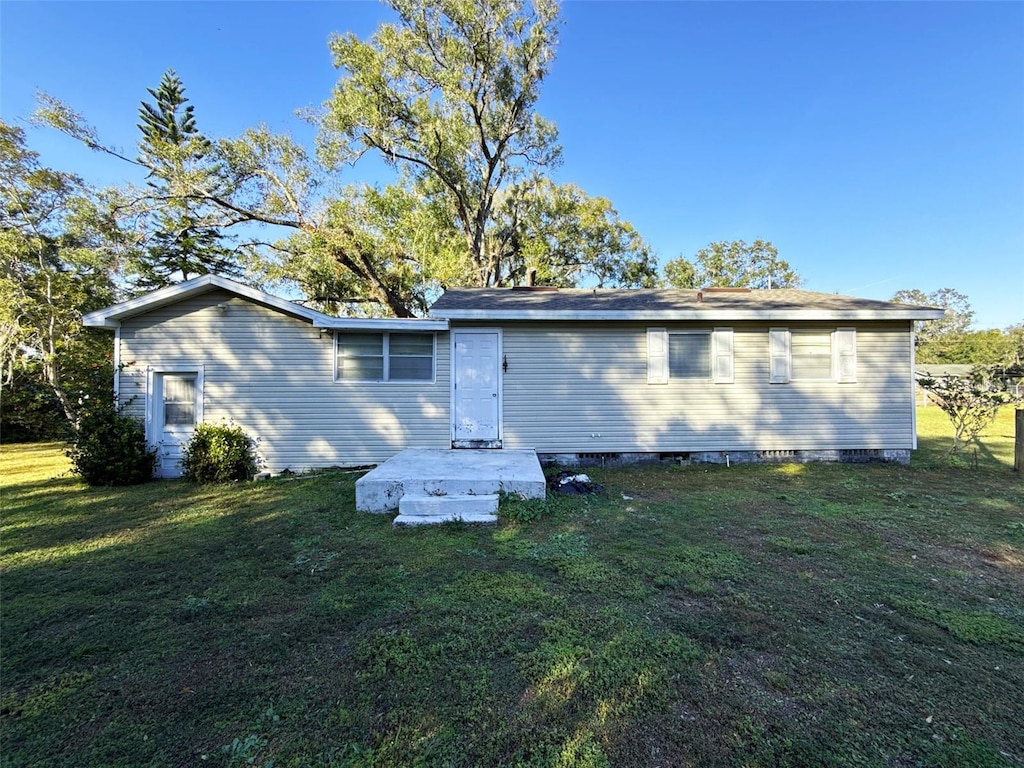 rear view of property with a yard