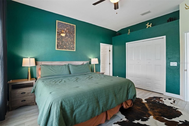 bedroom with ceiling fan, a closet, and light hardwood / wood-style flooring