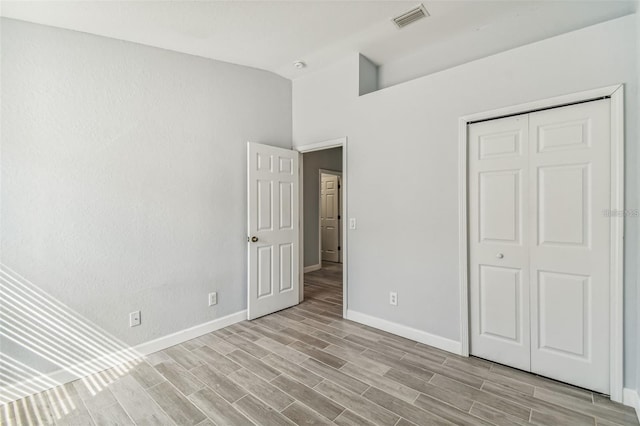 unfurnished bedroom featuring light wood-type flooring and a closet