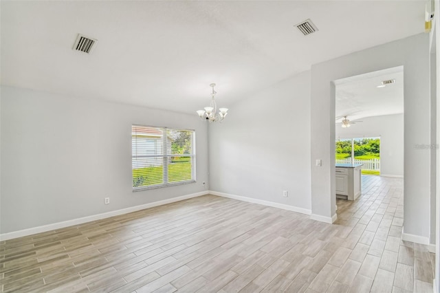 unfurnished room with ceiling fan with notable chandelier, light wood-type flooring, and a wealth of natural light