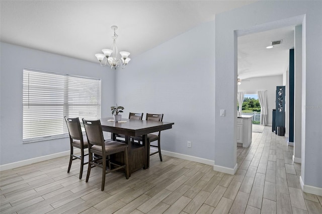 dining space with light hardwood / wood-style flooring and ceiling fan with notable chandelier