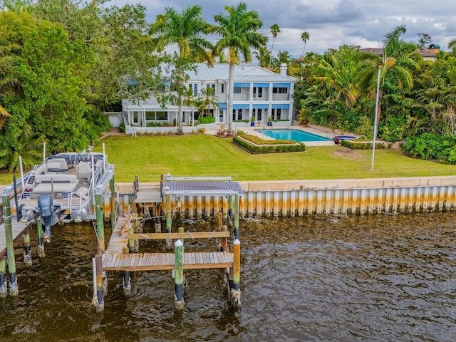 rear view of property featuring a patio area, a water view, a yard, and a balcony