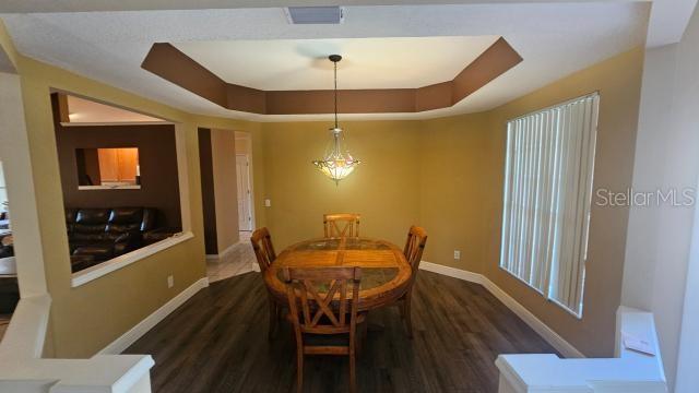 dining room featuring dark hardwood / wood-style floors and a tray ceiling