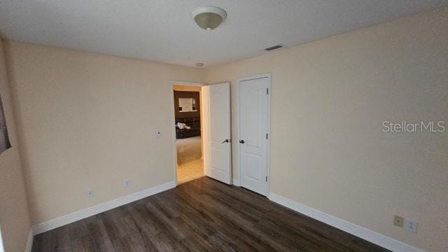 unfurnished room featuring dark hardwood / wood-style flooring