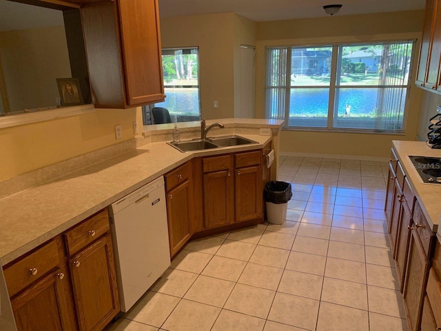 kitchen with dishwasher, a healthy amount of sunlight, light tile patterned floors, and sink