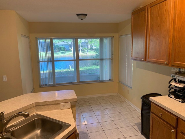 kitchen featuring a healthy amount of sunlight, light tile patterned flooring, and sink