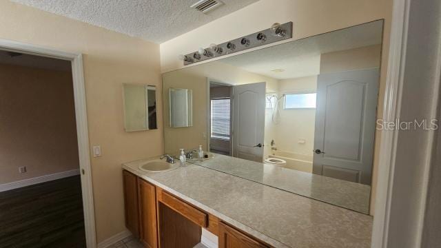 bathroom with vanity and a textured ceiling