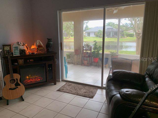 entryway featuring a water view, a fireplace, and light tile patterned floors