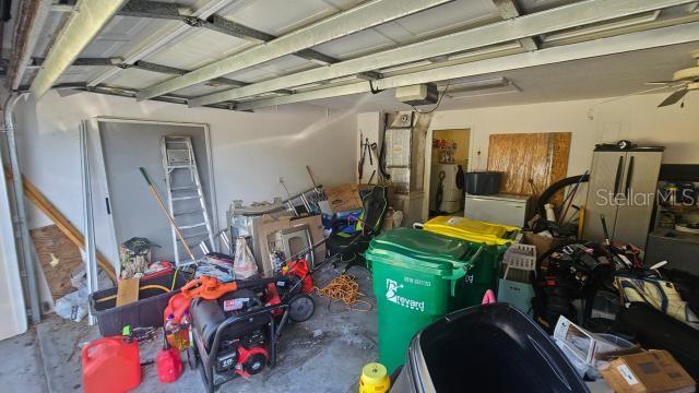 garage with a garage door opener and ceiling fan