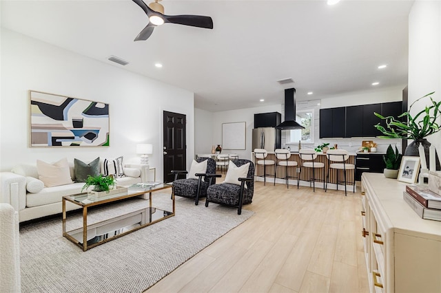 living room with ceiling fan and light hardwood / wood-style floors