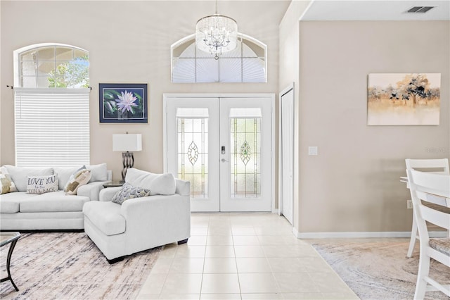 living room with french doors, light tile patterned floors, and a notable chandelier