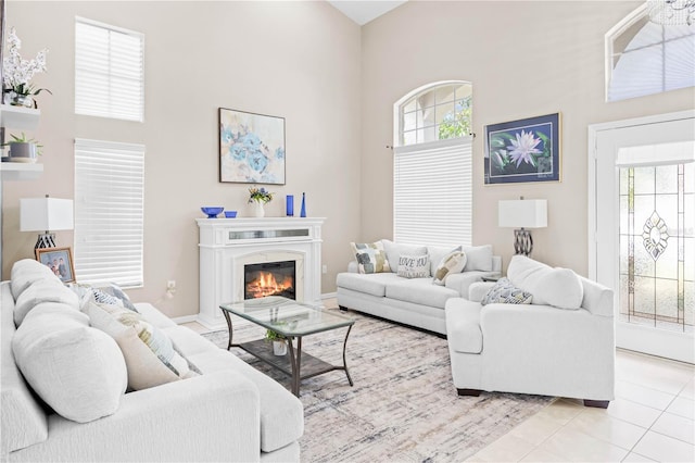 living room with a high ceiling and light tile patterned floors