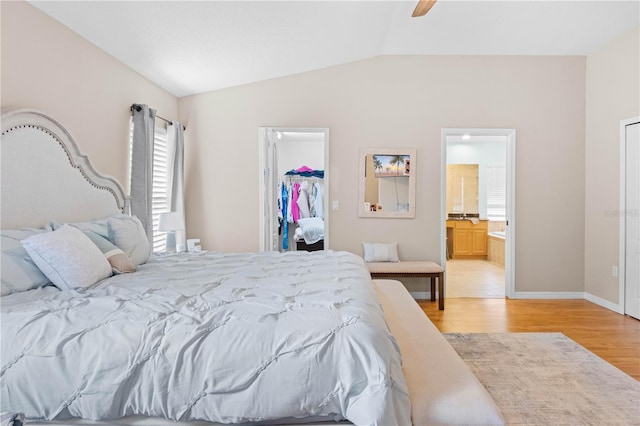 bedroom with a walk in closet, ceiling fan, connected bathroom, light hardwood / wood-style floors, and a closet