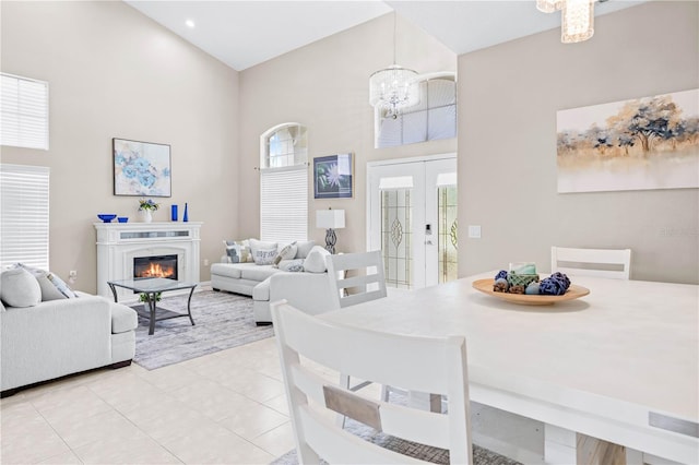 tiled dining room featuring a high ceiling and an inviting chandelier