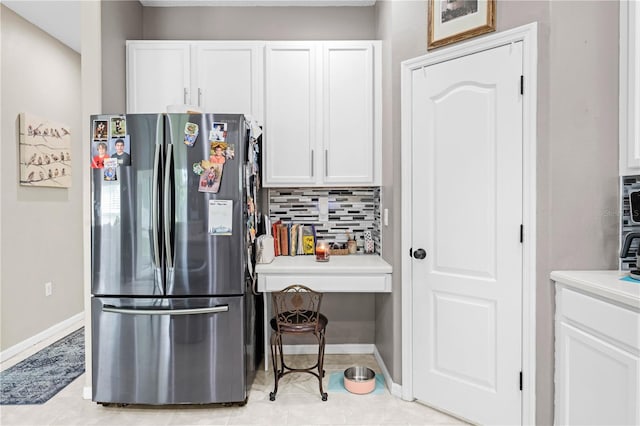 kitchen featuring white cabinets, stainless steel fridge, backsplash, and light tile patterned floors