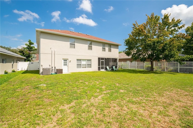 back of house featuring a yard and central AC unit