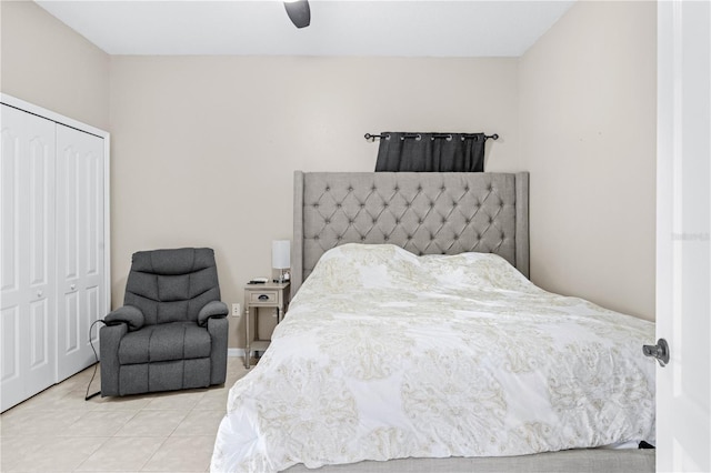 bedroom with ceiling fan, light tile patterned floors, and a closet