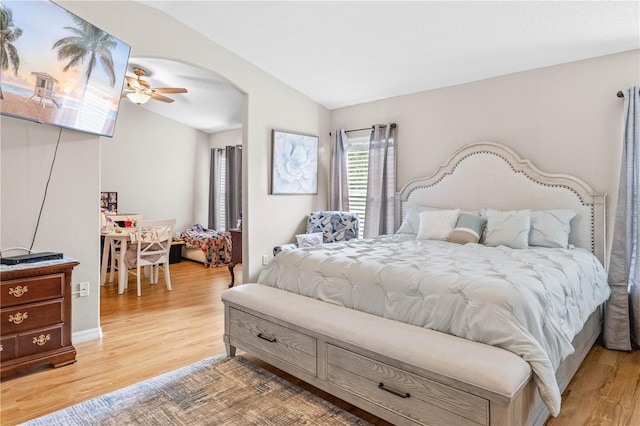 bedroom featuring light hardwood / wood-style floors, vaulted ceiling, and ceiling fan