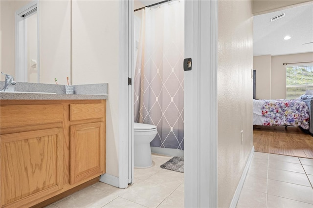 bathroom with toilet, vanity, and tile patterned floors